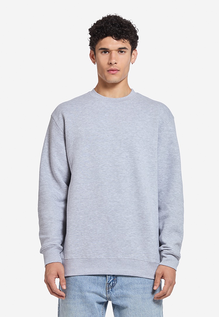 A man in the LS14004 premium crewneck sweatshirt in heather grey, from the front